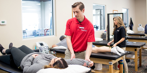 Physical therapist at Dynamic Physical Therapy & Sports Medicine doing a body checkup on a girl.